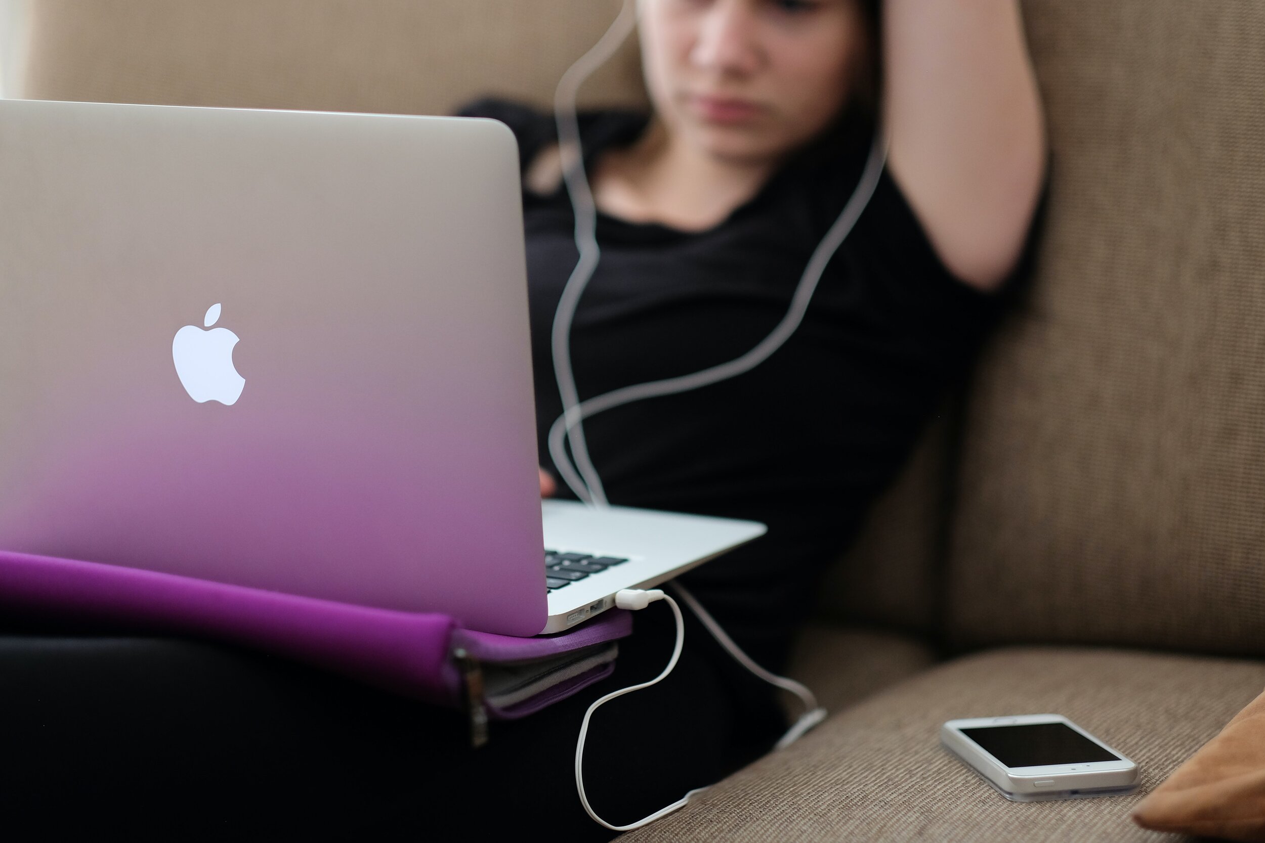 girl on apple macbook with headphones in